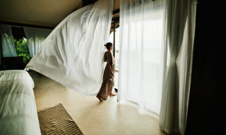A woman enjoying the view from a Classico A Sonesta Collection hotel room